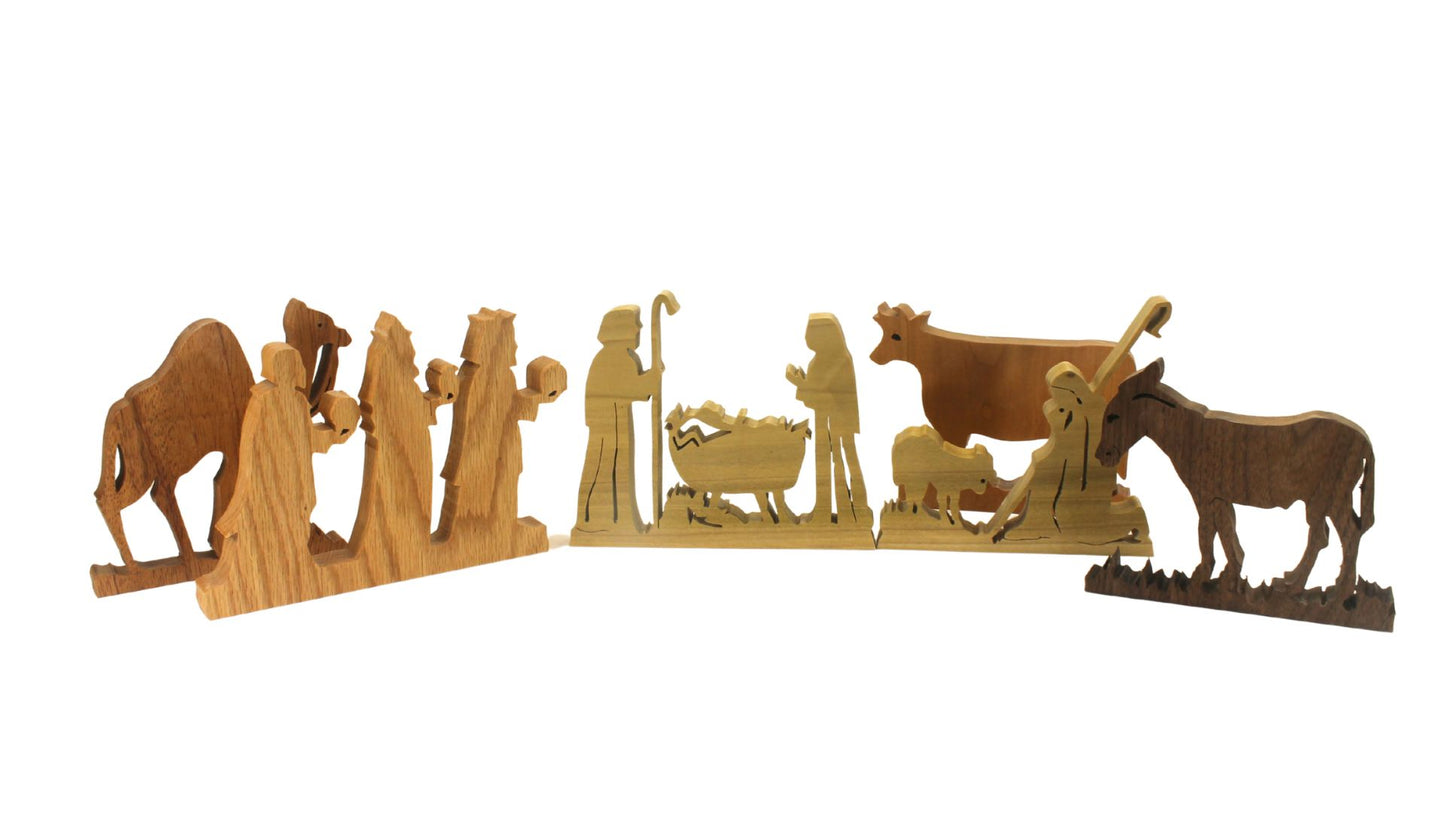Nativity set, freestanding figures and animals. Mary, Joseph, baby Jesus, shepherd, kings, donkey, cow, camel. Hand cut from hardwoods