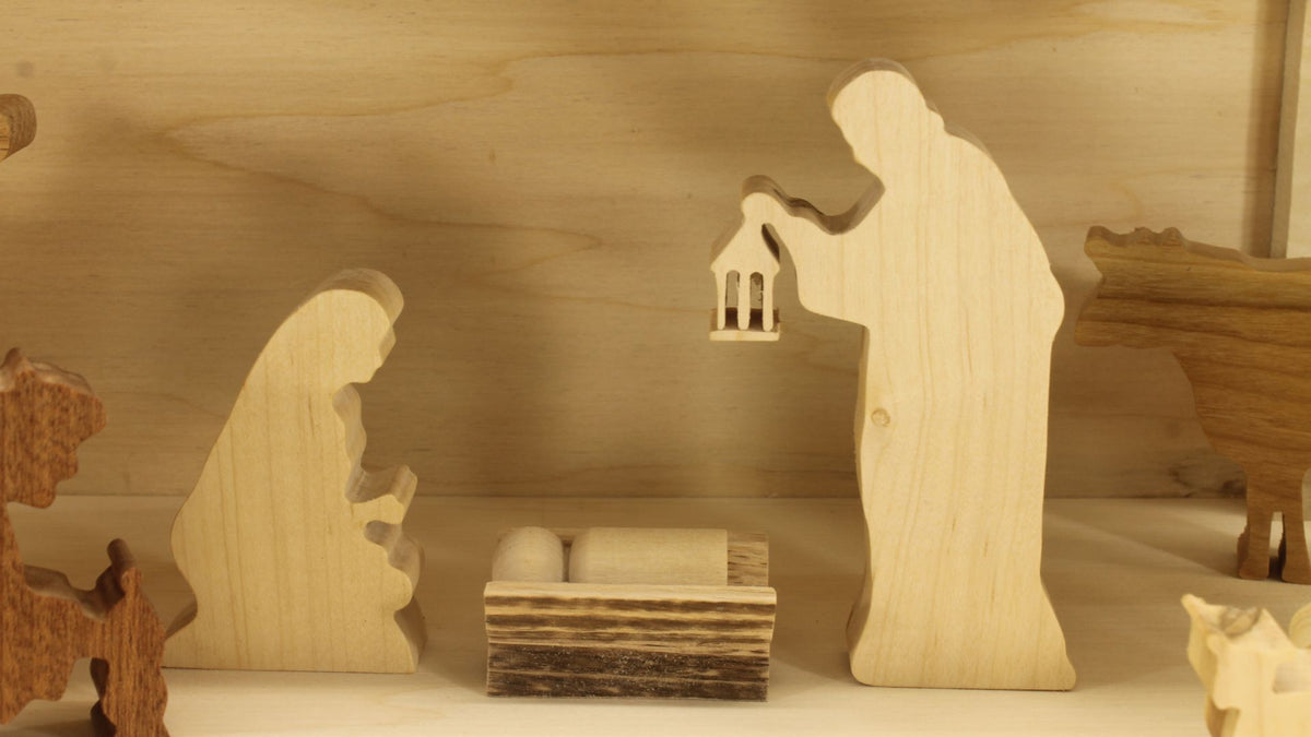 Multi-piece wood nativity with stable and figures, town of Bethlehem in the background