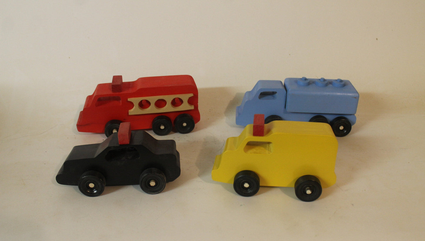 Handmade toy wooden vehicles. The set includes a tank truck, police car, ambulance, and  fire truck. Handmade from solid wood and brightly painted